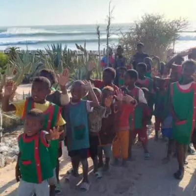 Groupe d’enfants saluant des voyageurs près d’un village côtier à Madagascar.