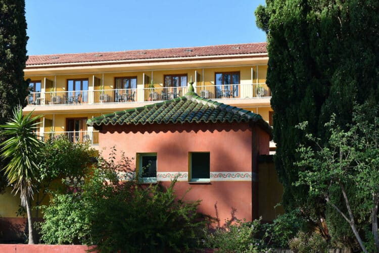 Façade colorée de l'hôtel en Balagne entourée de verdure