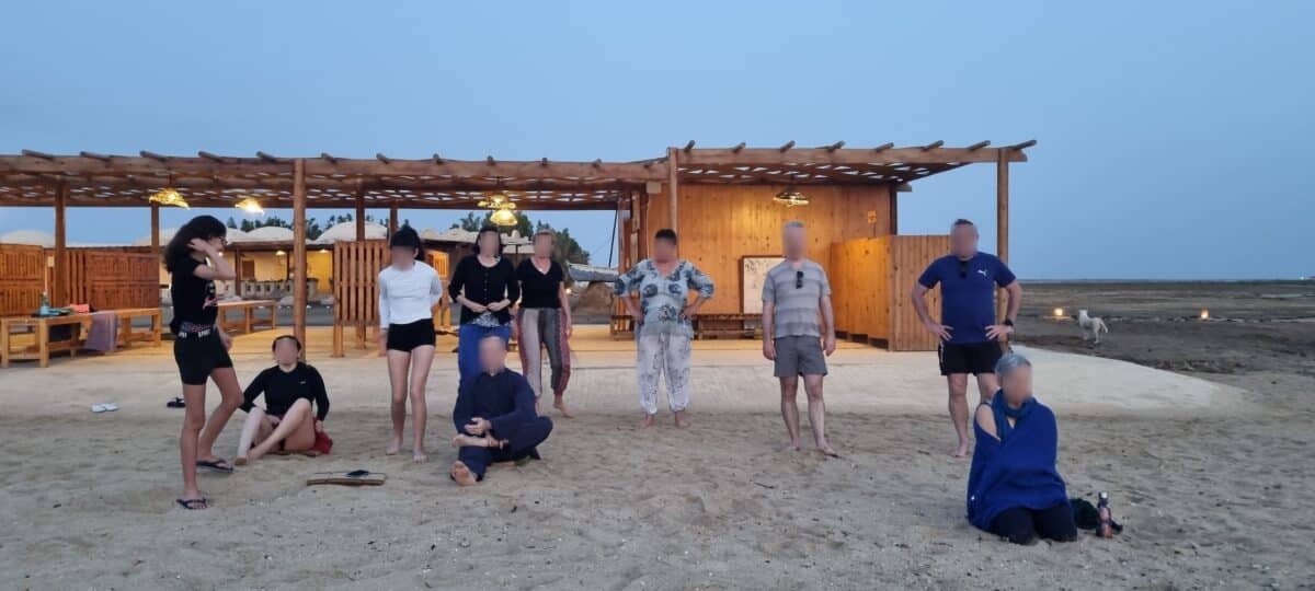 Groupe pratiquant le Qi Gong dans un centre de bien-être en bord de plage.