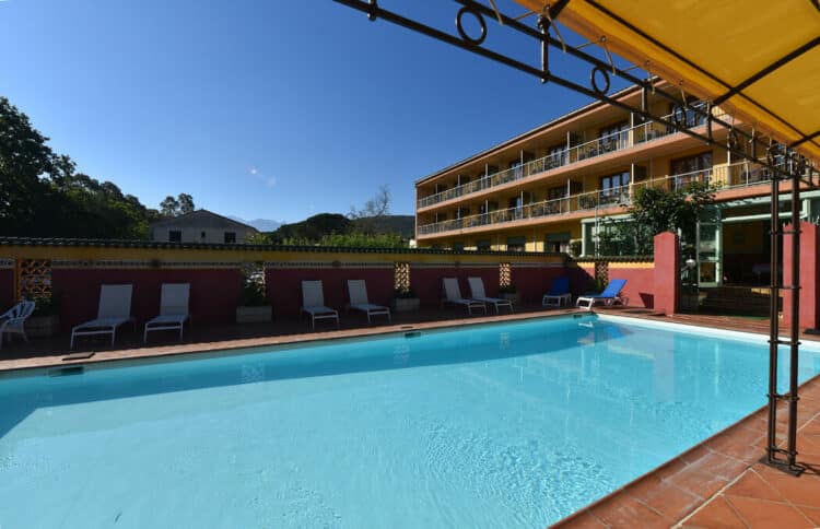 Piscine extérieure avec transats et vue sur les montagnes corses