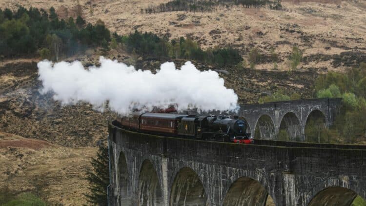 Train à vapeur traversant le viaduc de Glenfinnan dans les Highlands écossais