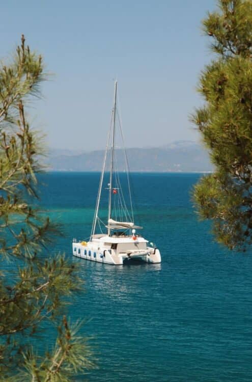 Catamaran naviguant sur une mer turquoise entre la Corse et la Sardaigne.