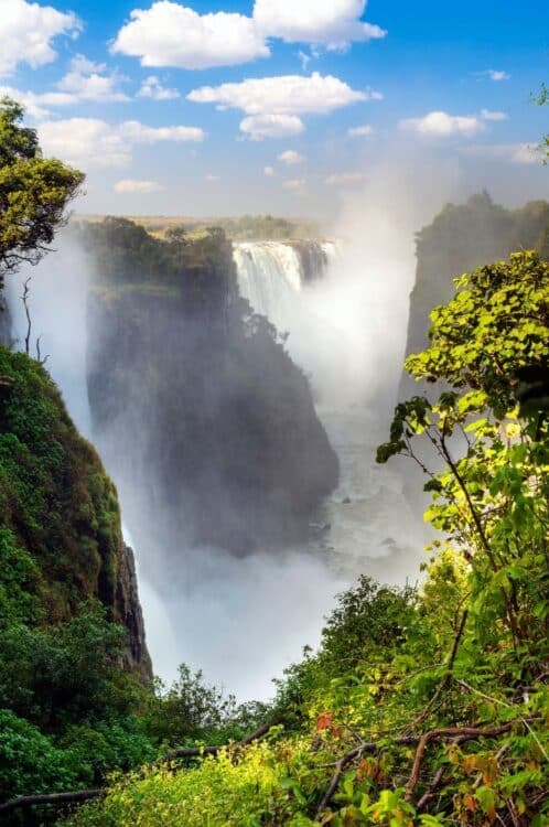 Vue panoramique des chutes Victoria entourées d'une végétation luxuriante.