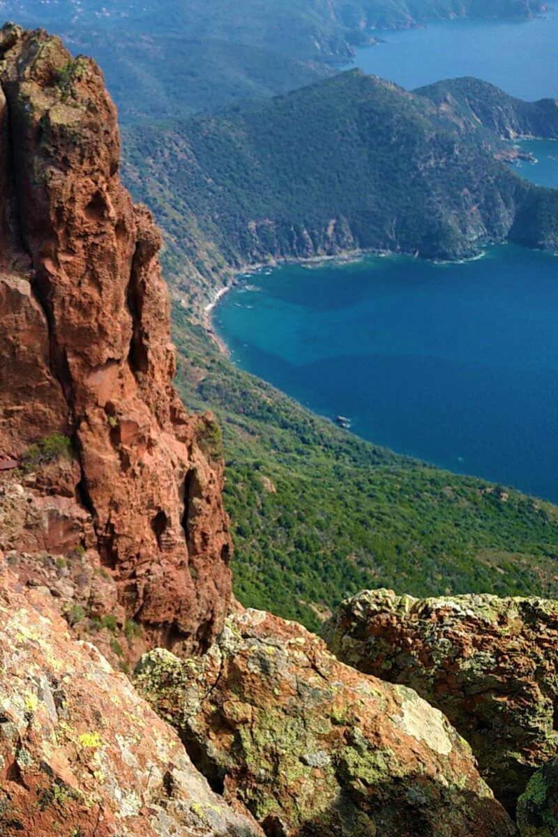 Vue aérienne des falaises rouges plongeant dans la mer Méditerranée.