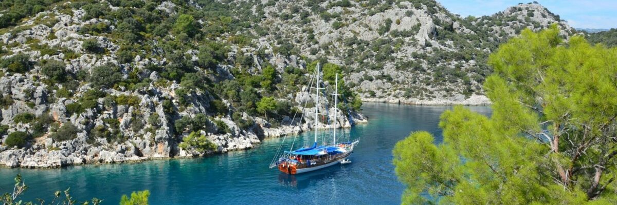 Croisière en caïque dans une crique sauvage de Méditerranée lors d’un voyage en petit bateau à taille humaine
