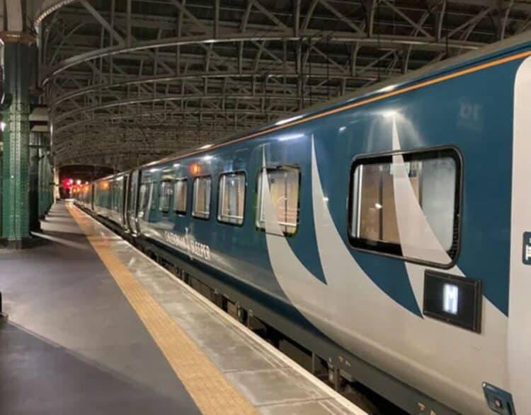 Train Caledonian Sleeper à quai dans une gare de nuit avec éclairage urbain