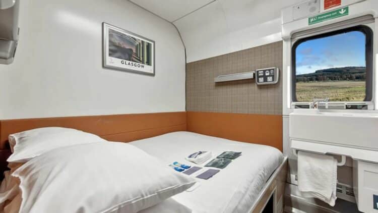 Cabine double du train de nuit Caledonian Sleeper avec lit et fenêtre sur le paysage écossais