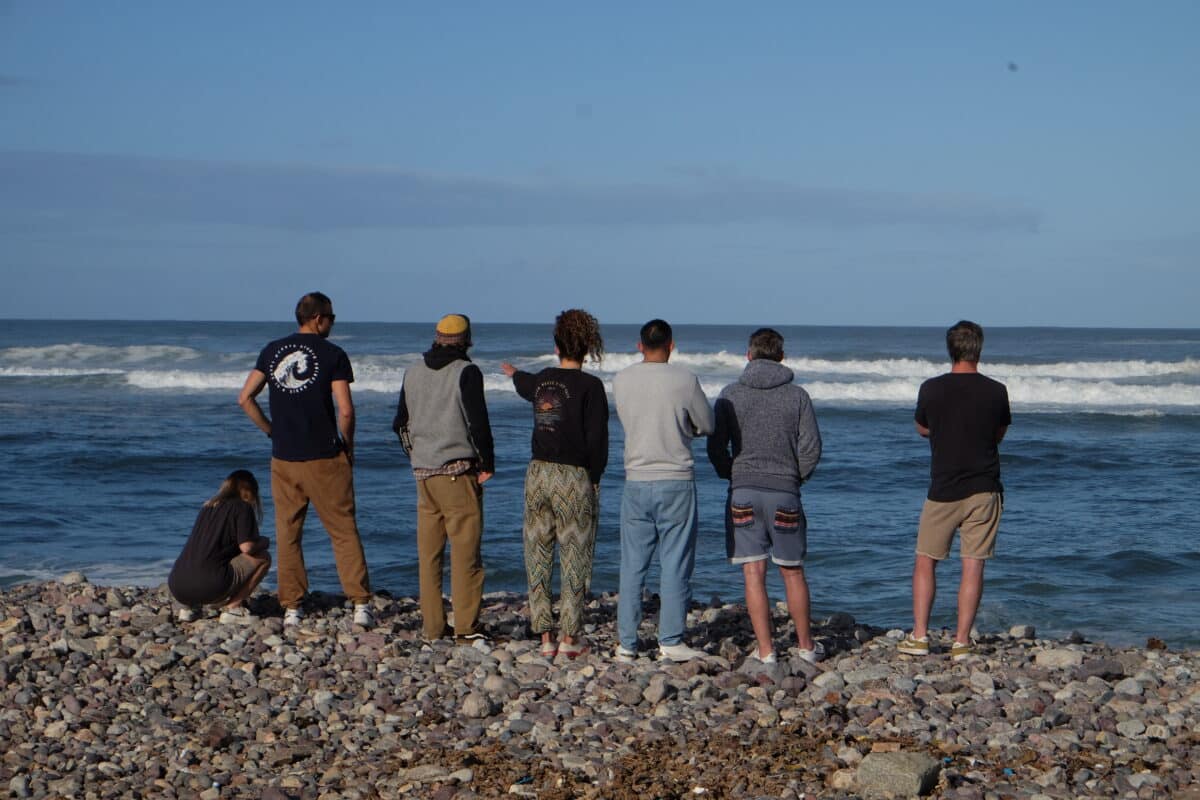 Groupe de surfeurs observant les vagues au Maroc.