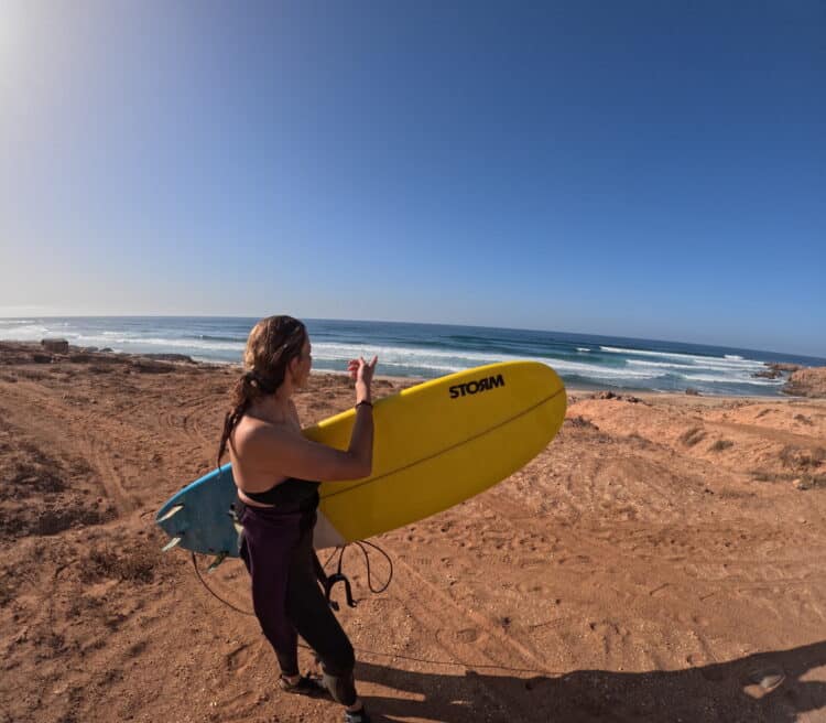 Surfeuse observant l'océan Atlantique au Maroc - Surf Trip avancé.