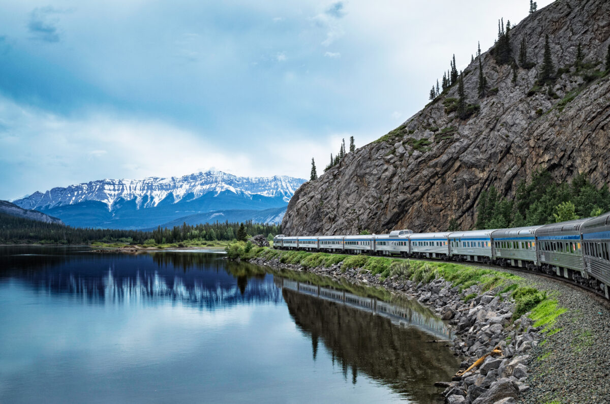 Train Le Canadien traversant les montagnes et lacs du Canada