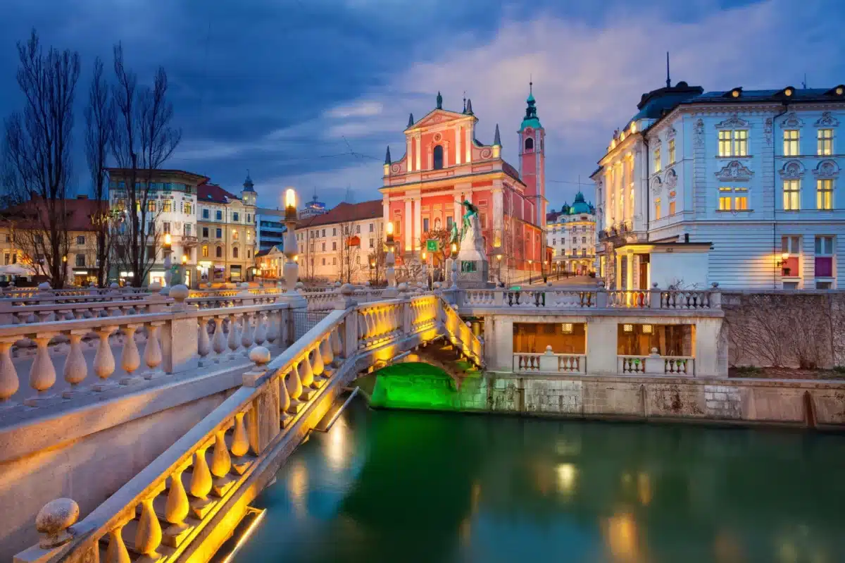 Vue nocturne du pont triple et de l’église rose à Ljubljana