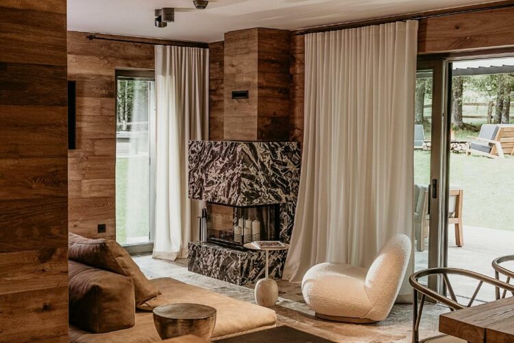 Salon lumineux d’un chalet moderne avec cheminée en pierre marbrée et mobilier contemporain