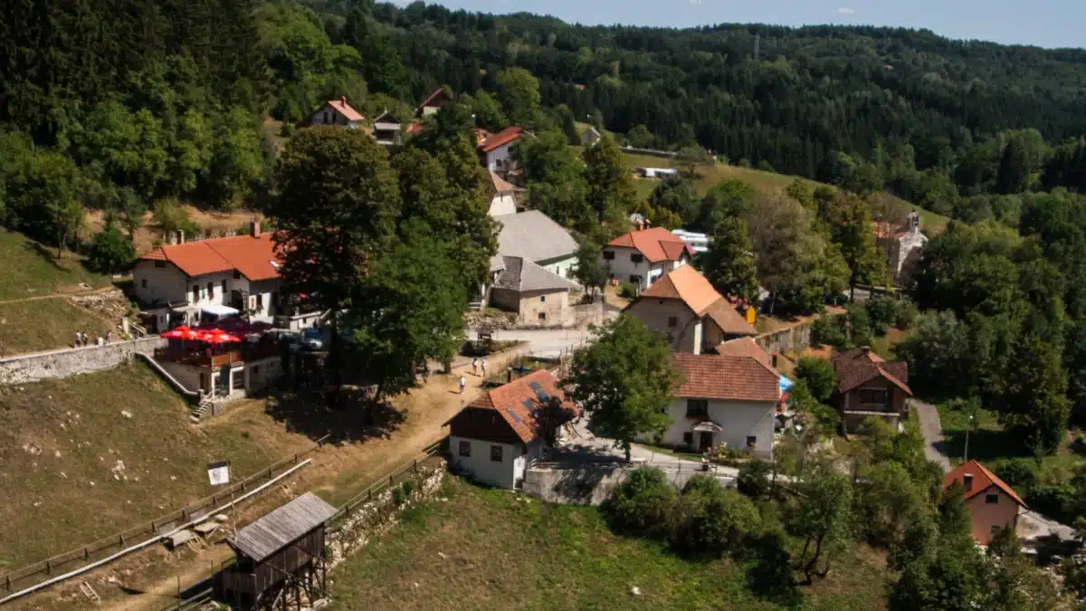 Village traditionnel slovène niché dans la forêt près de Postojna