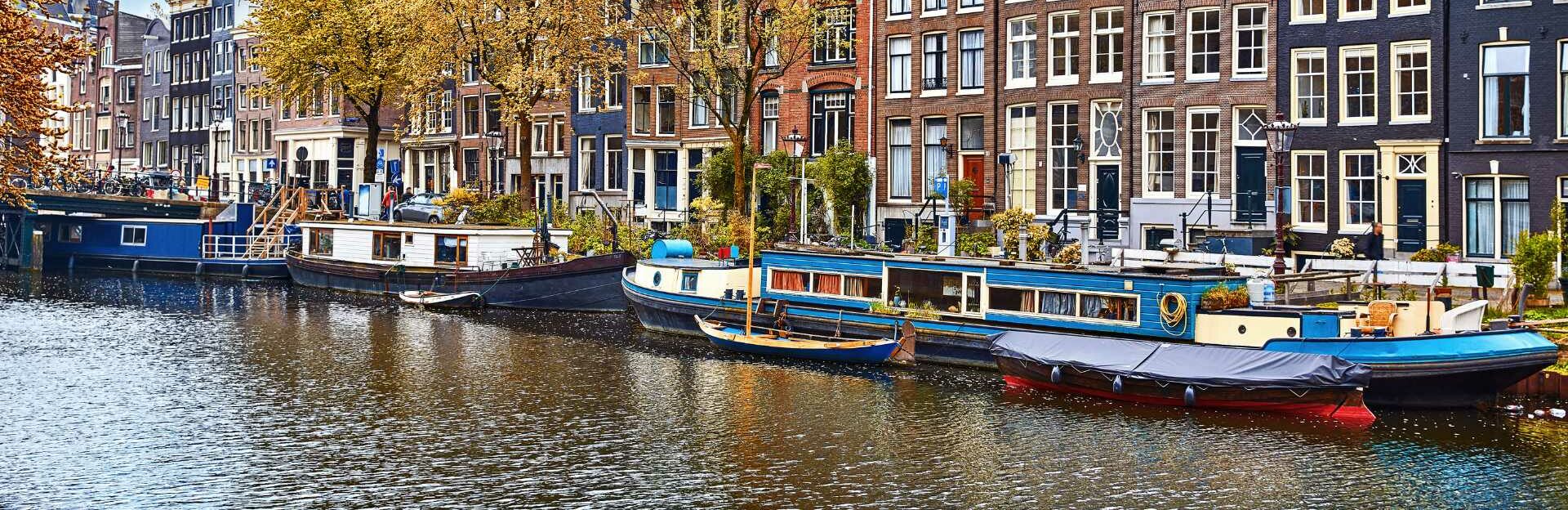 Canal bordé de maisons à pignons typiques à Amsterdam à l’automne