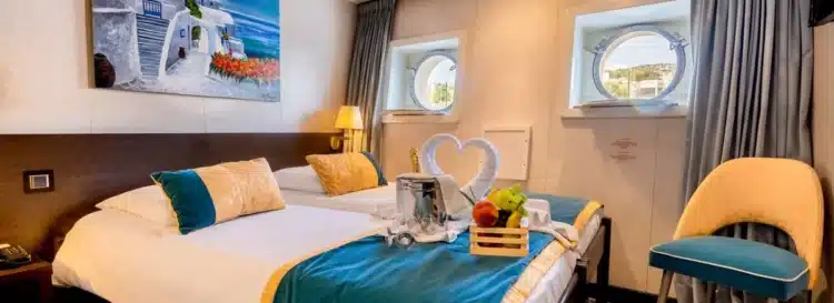 Cabine avec lits jumeaux et deux hublots à bord de la croisière en Italie du Sud