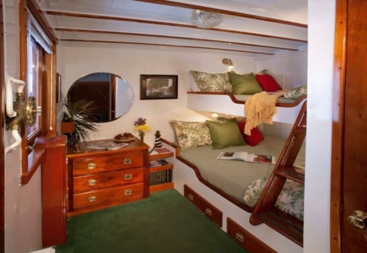 Cabine confortable avec lits superposés en bois à bord d’un navire d’expédition en Alaska.
