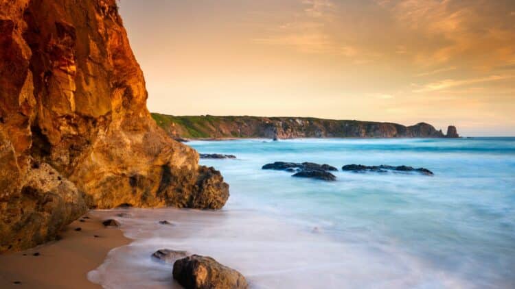 Côte rocheuse sauvage en Australie avec plage de sable et falaises au coucher du soleil