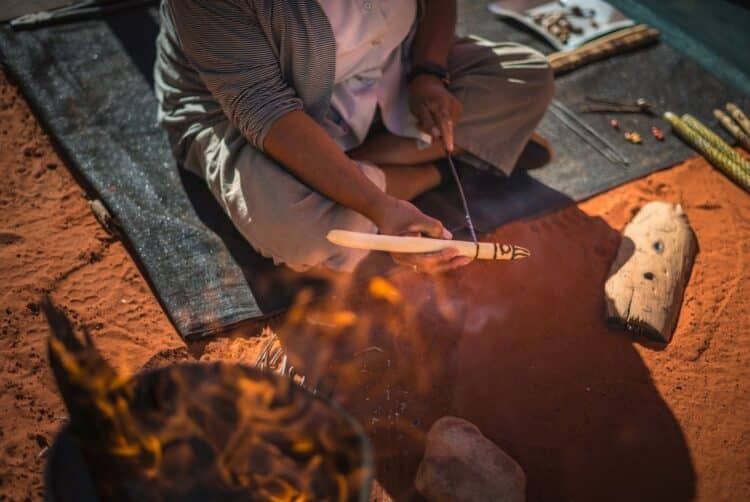 Atelier culturel dans le désert australien avec démonstration d’artisanat traditionnel près de Kings Canyon.