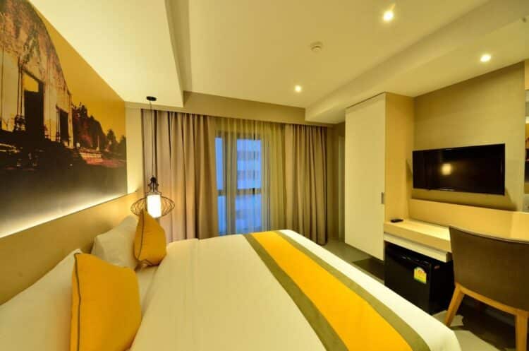 Chambre moderne et lumineuse de l’hôtel Bizotel Premier à Bangkok avec lit double et bureau
