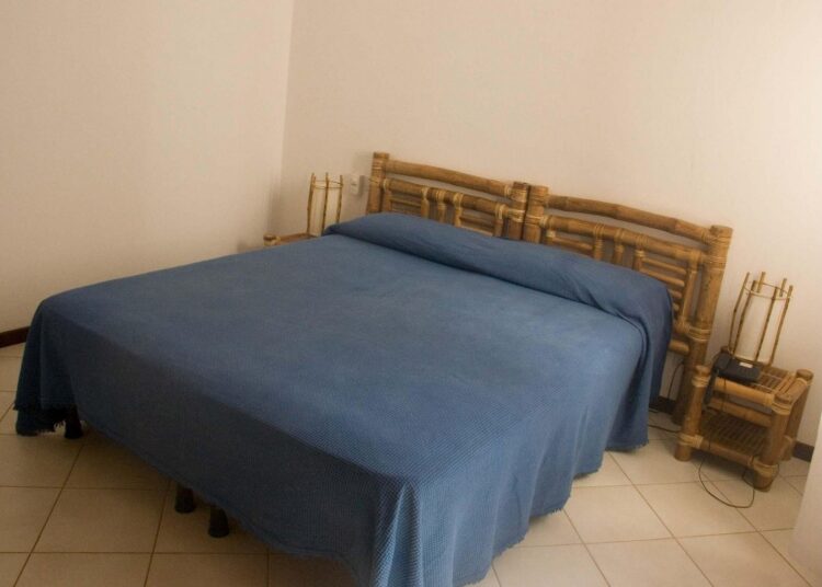 Chambre simple et confortable à Ca Nicola au Cap-Vert avec lit double et mobilier en bois.