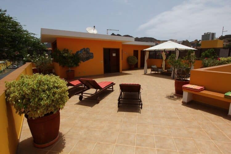 Terrasse panoramique du Kira’s Boutique Hotel au Cap-Vert avec transats et coin ombragé.