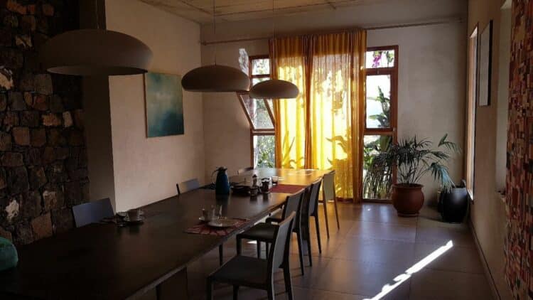 Salle de restaurant chaleureuse à la Quinta Cochete au Cap-Vert avec grandes tables.