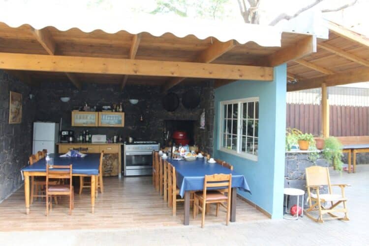 Espace de restauration convivial à la Casa JC au Cap-Vert avec tables en bois.