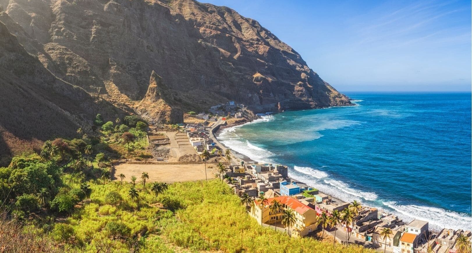 Vue aérienne d’un village côtier de Vila das Pombas au Cap-Vert entre montagne et océan.