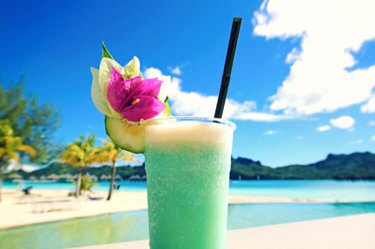 Cocktail tropical vert servi face au lagon en Polynésie