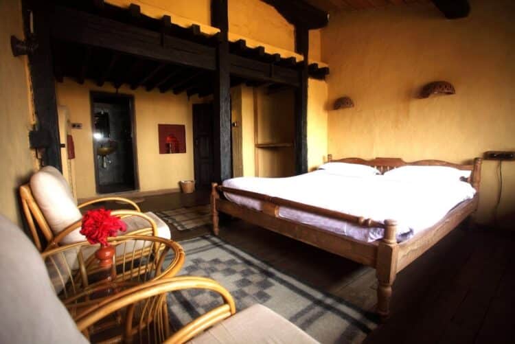 Chambre traditionnelle népalaise avec lit en bois et mobilier artisanal