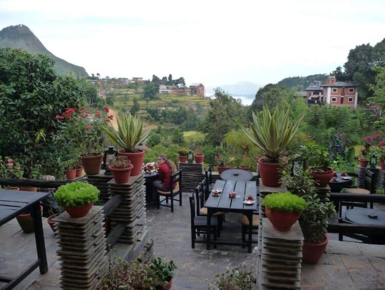 Terrasse de lodge au Népal avec vue sur les collines verdoyantes et les villages