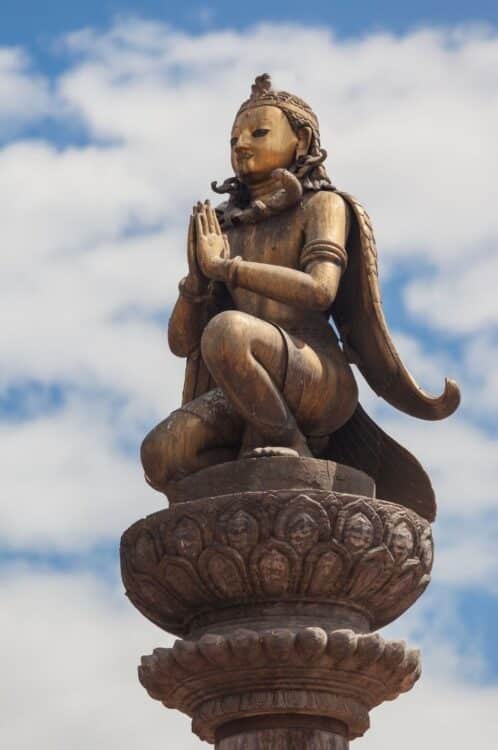Statue sacrée sculptée sur une colonne dans un site religieux de Katmandou
