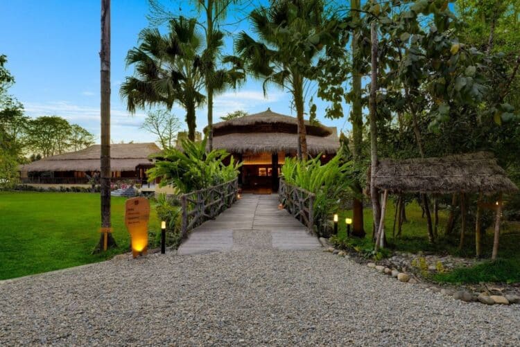 Façade du Tigerland Safari Lodge avec allée et végétation tropicale