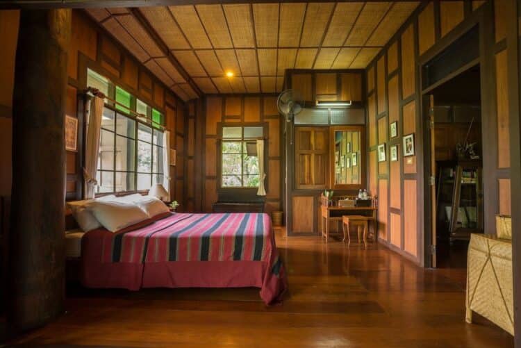 Chambre traditionnelle du Khum Lanna Lodge en bois avec décoration locale
