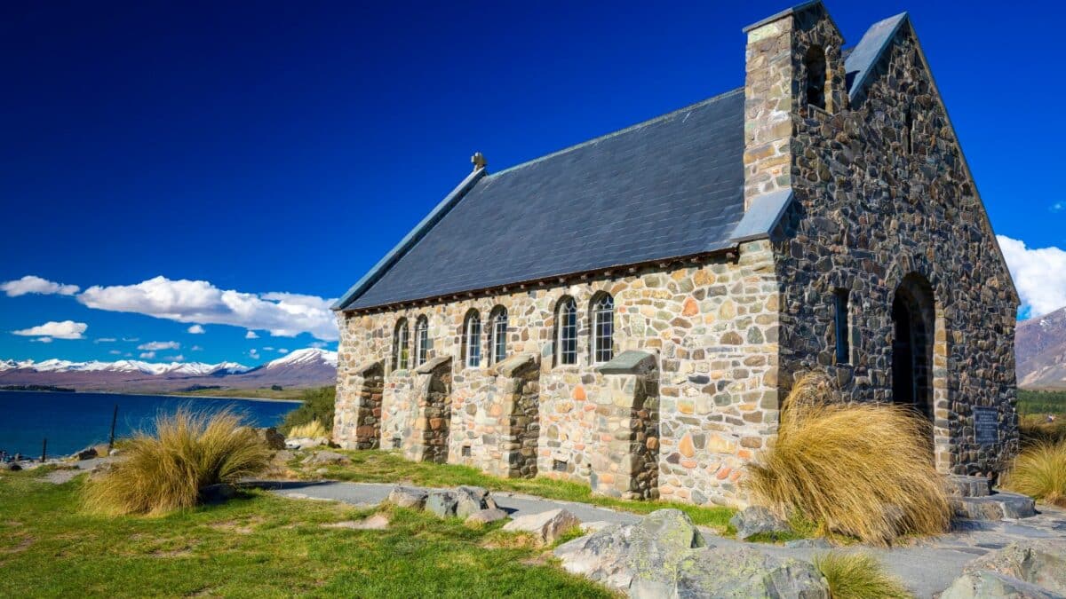 Église en pierre du Good Shepherd au bord du lac Tekapo avec montagnes enneigées en Nouvelle-Zélande.