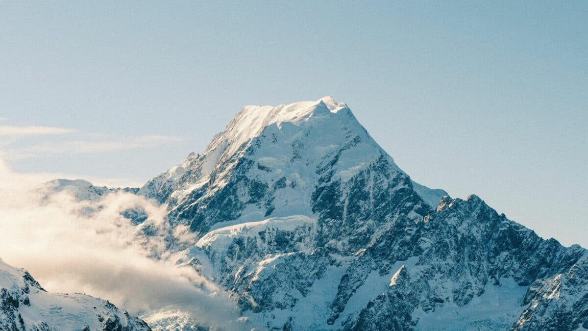 Sommet enneigé dans la région du mont Cook entouré de nuages en Nouvelle-Zélande.
