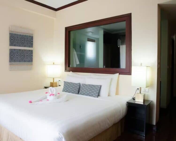 Chambre lumineuse du Parasol Blanc Hotel avec lit double, décoration soignée et éclairage doux.