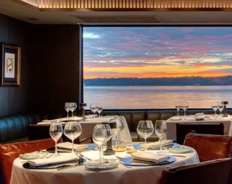 Salle de restaurant elegante a bord du bateau Aqua Nera avec vue sur le fleuve en Amazonie peruvienne.