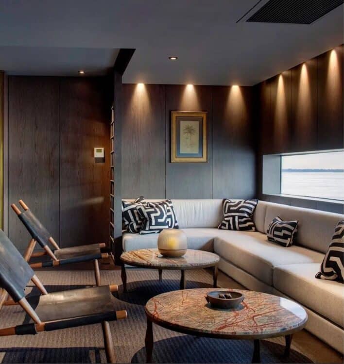 Salon lounge elegant avec canapes et vue sur le fleuve a bord du bateau Aqua Nera en Amazonie peruvienne.