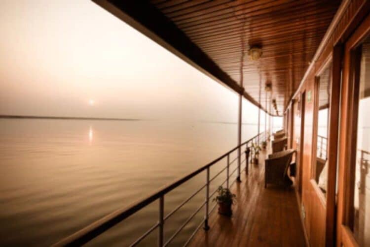 Pont extérieur du bateau RV Kindat Pandaw avec vue sur le fleuve Brahmapoutre au coucher du soleil.