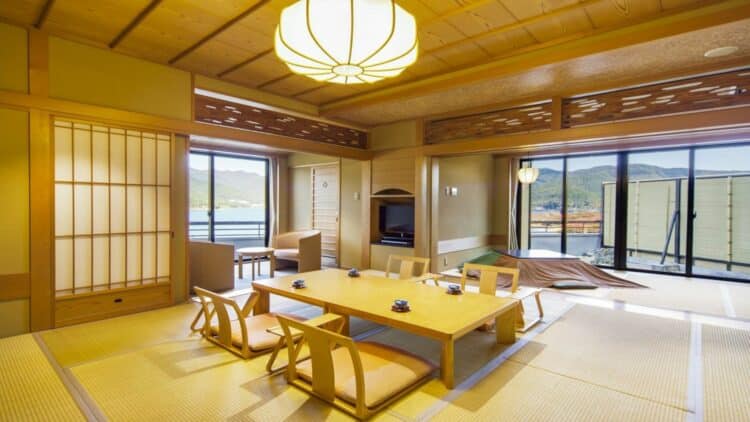 Chambre traditionnelle japonaise dans un ryokan avec tatamis, table basse et vue sur le lac Kawaguchiko
