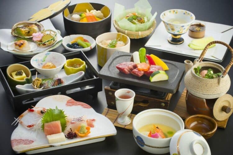 Repas traditionnel japonais kaiseki avec plusieurs plats raffinés présentés sur une table
