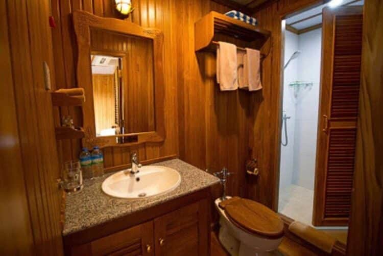 Salle de bain privative en bois avec douche dans une cabine du RV Kindat Pandaw.