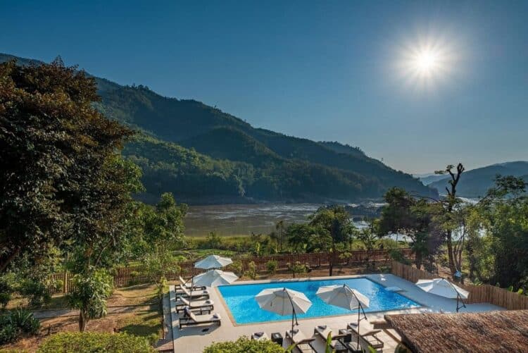 Piscine du Sanctuary Pakbeng Lodge avec vue sur le fleuve et les collines environnantes.