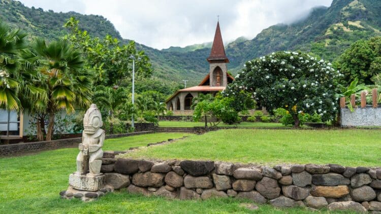 Village de Tahuata avec église, végétation tropicale et montagnes des Marquises.