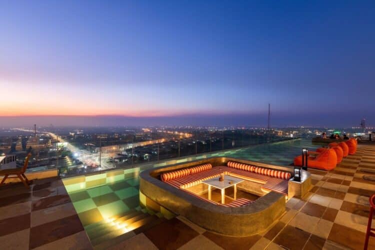 Piscine d’hôtel entourée de transats et de végétation à Ayutthaya.
