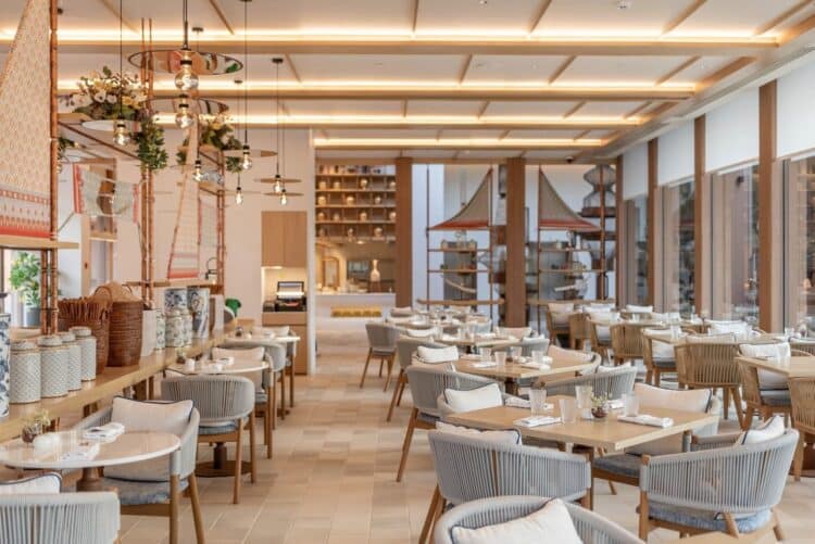 Restaurant lumineux d’hôtel avec tables dressées et décoration soignée.