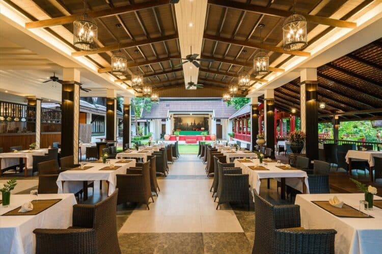 Restaurant ouvert de style thaïlandais avec tables dressées et décor raffiné.