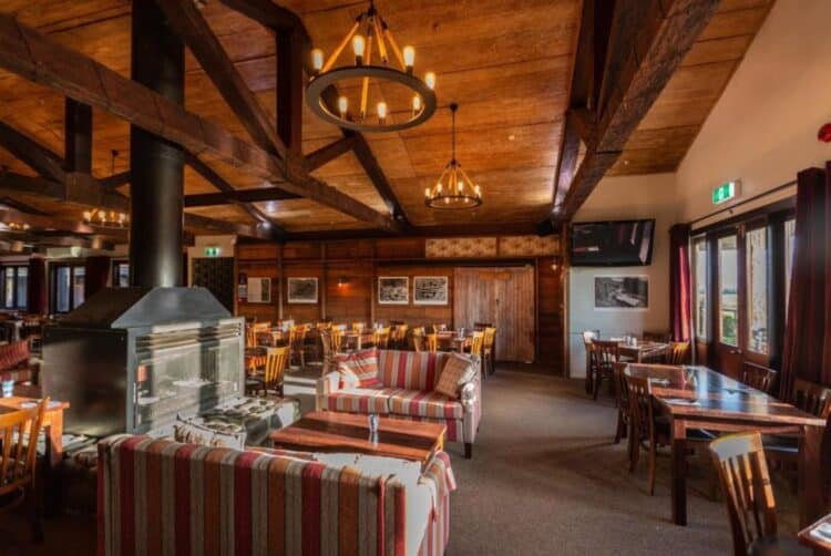Restaurant du Park Hotel Ruapehu avec cheminée centrale et décoration boisée.