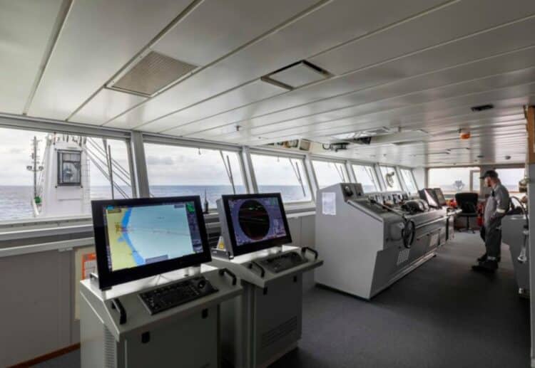 Passerelle de navigation d’un navire d’expédition en Antarctique avec écrans radar et vue sur l’océan polaire.